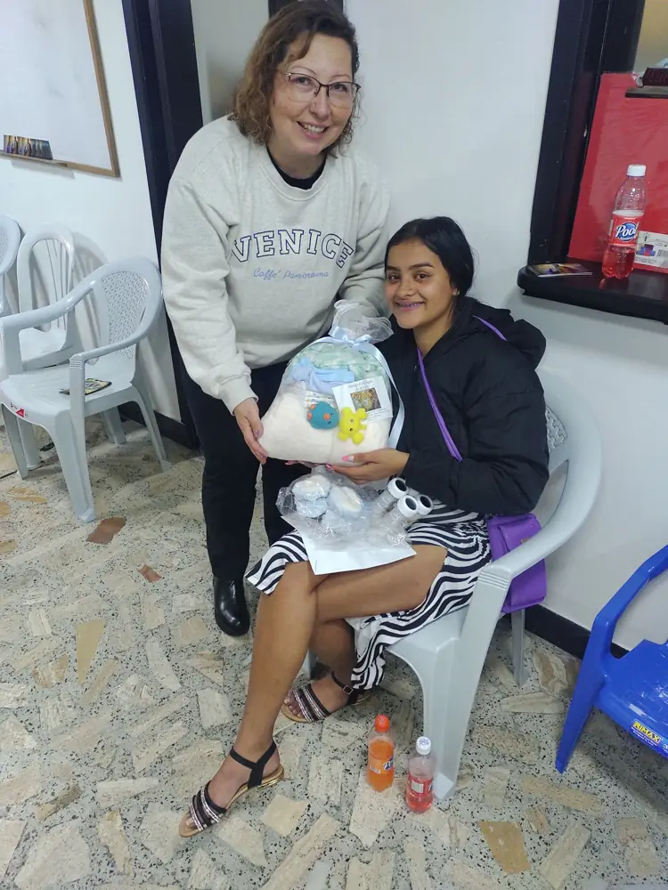 Una voluntaria entrega un kit a una mamá