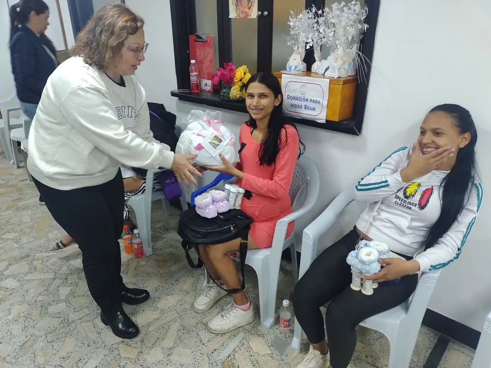Una voluntaria entrega un regalo a una mamá
