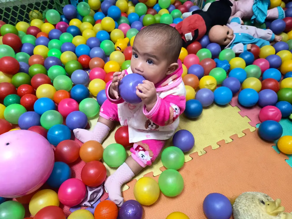 Bebé feliz entre pelotas de colores