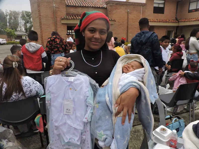 Mamá muestra la ropa que recibió para su bebé