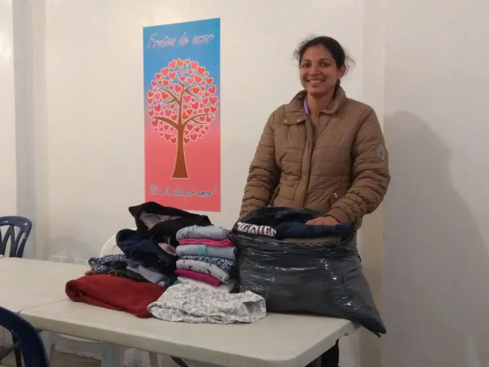 Una mamá gestante con la ropa para su bebé