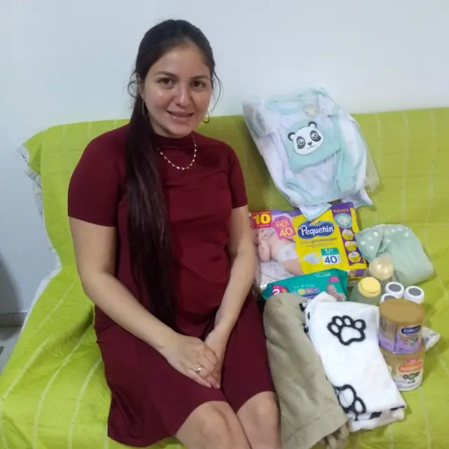 Mamá gestante sonríe junto a su kit