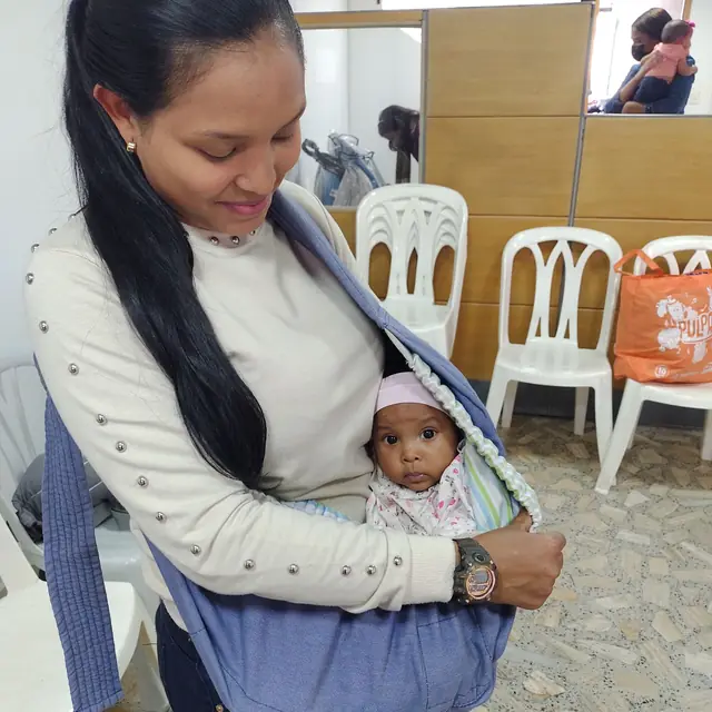 Mamá carga a su bebé en un fular