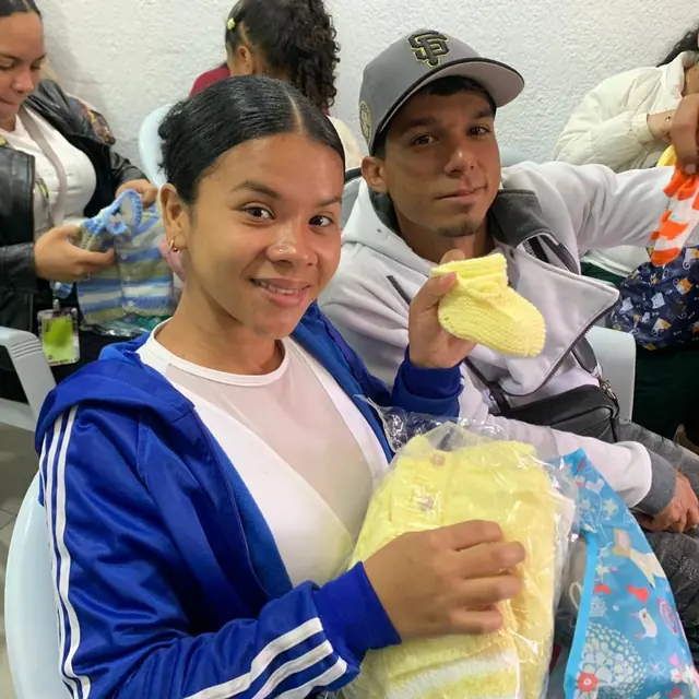 Mamás sonrientes reciben ropa para sus bebés