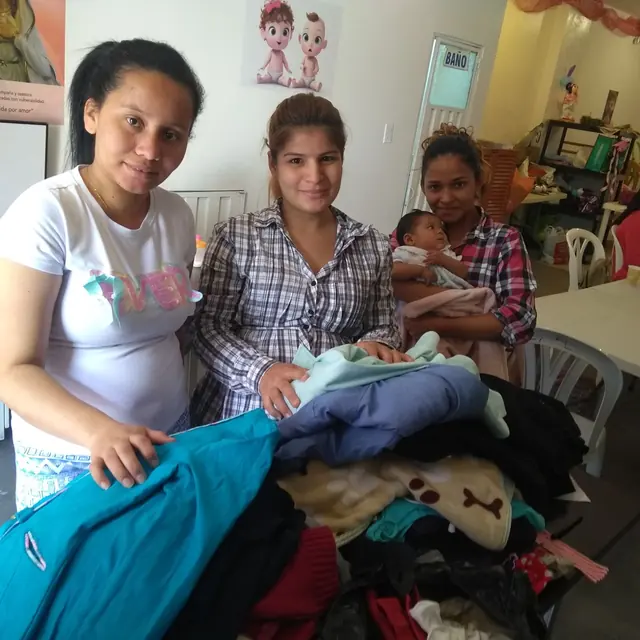 Dos mamás reciben ropa para sus bebés